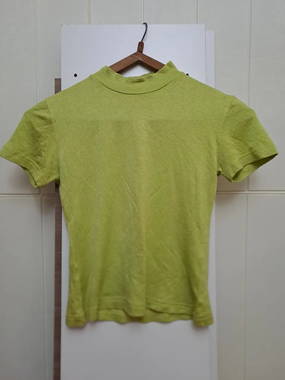 Remera verde lima de cuello alto y mangas cortas.