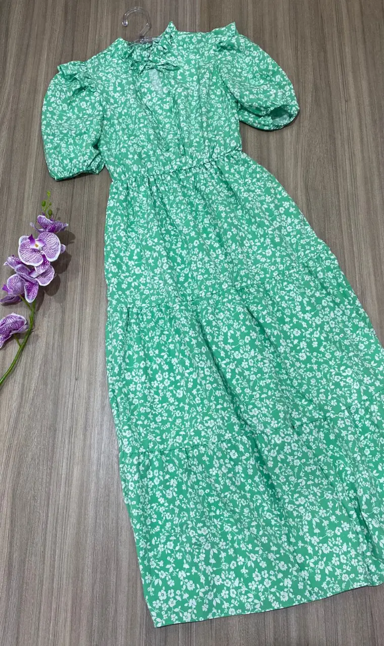Vestido largo con estampado floral en tonos verdes y blancos. Diseño con mangas cortas abullonadas, cintura elástica abarca talle S y M hasta 95 de busto 85 cintura. Falda con volados. Ideal para un look fresco y femenino. Marca: importado de Brasil