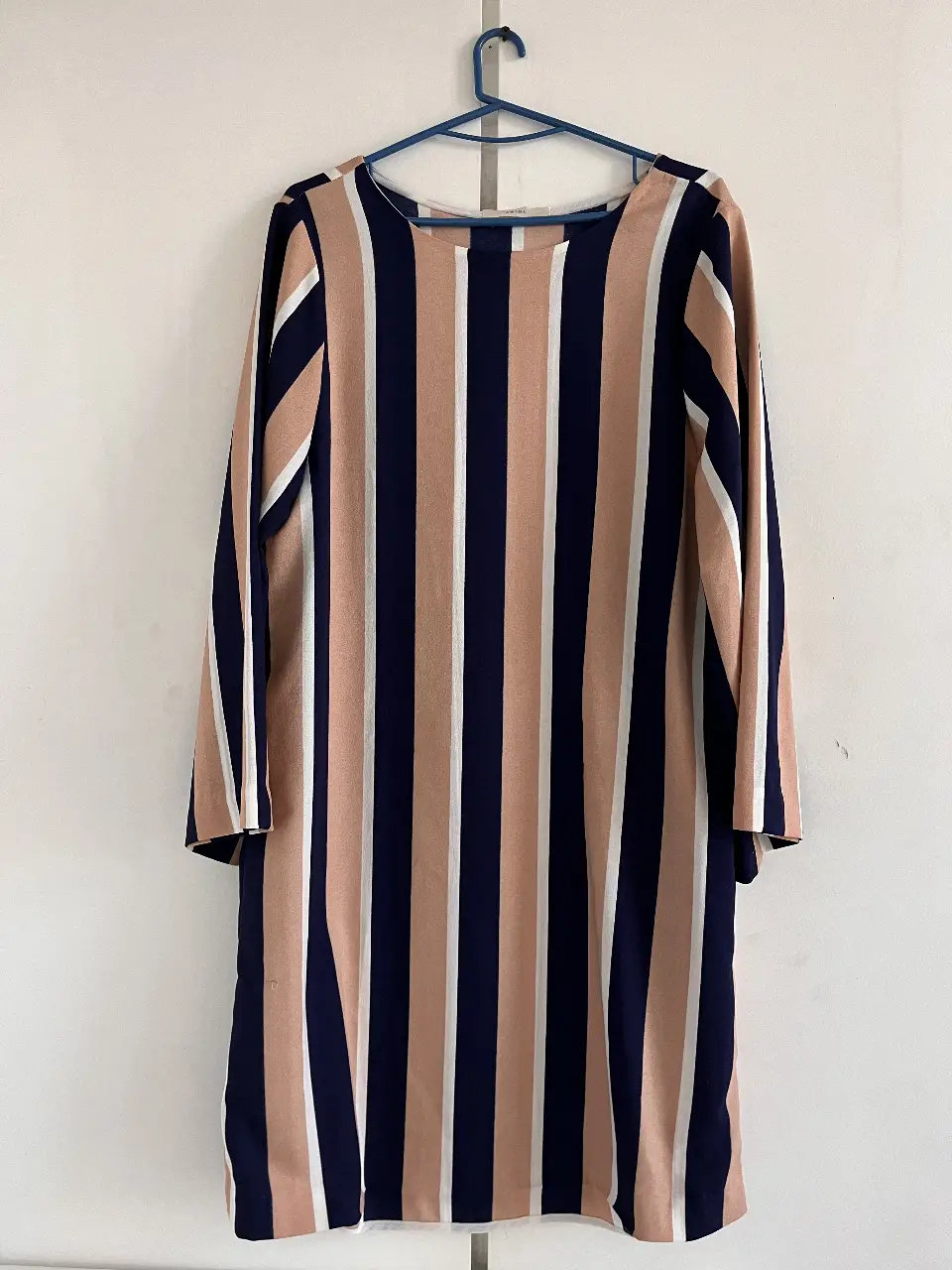 Vestido midi a rayas verticales en tonos nude, azul marino y blanco. Cuello redondo y mangas largas. Ideal para un look casual y elegante.