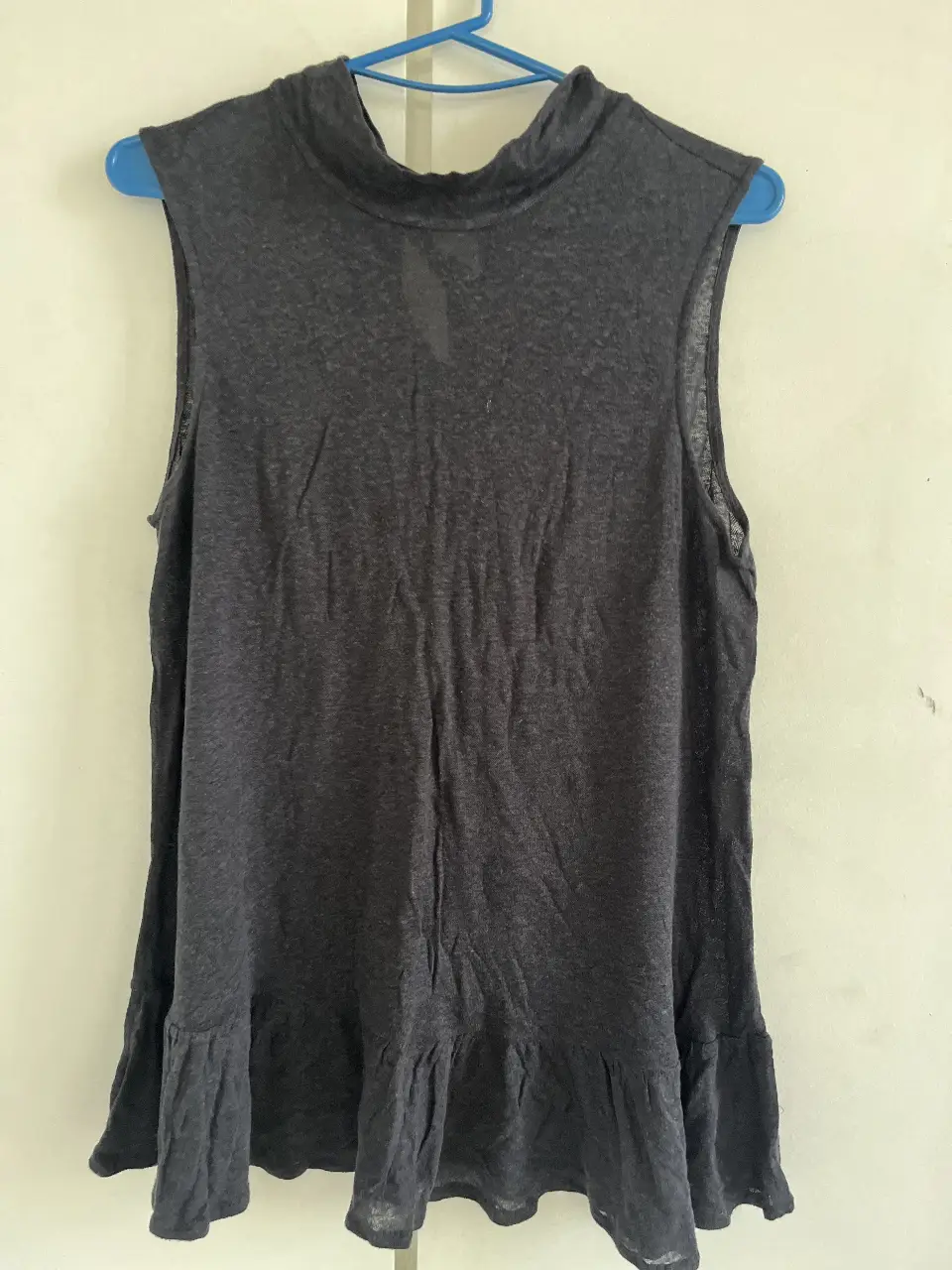 Musculosa de mujer, color gris oscuro, con cuello alto y volados en el ruedo. Ideal para un look casual y fresco.
