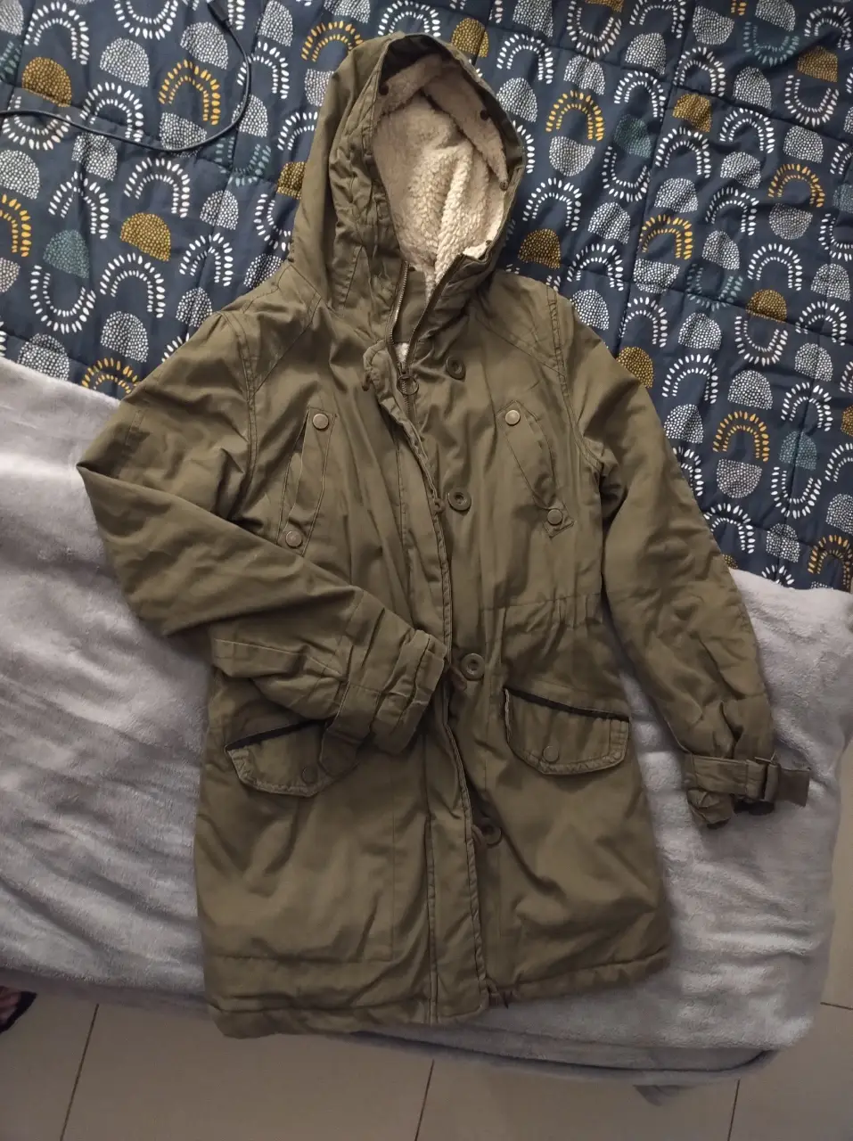 Campera parka verde militar con capucha y forro de piel sintética. Ideal para el invierno, con bolsillos amplios y ajuste en la cintura. Talle S.