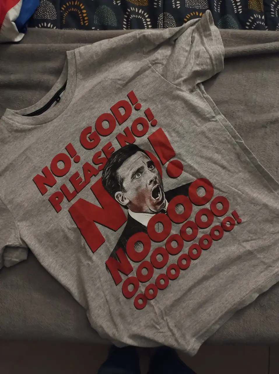 Remera gris con estampado de Michael Scott de la serie The Office gritando "NOOOOOOOO!". Ideal para fans de la serie y para un look casual y divertido.