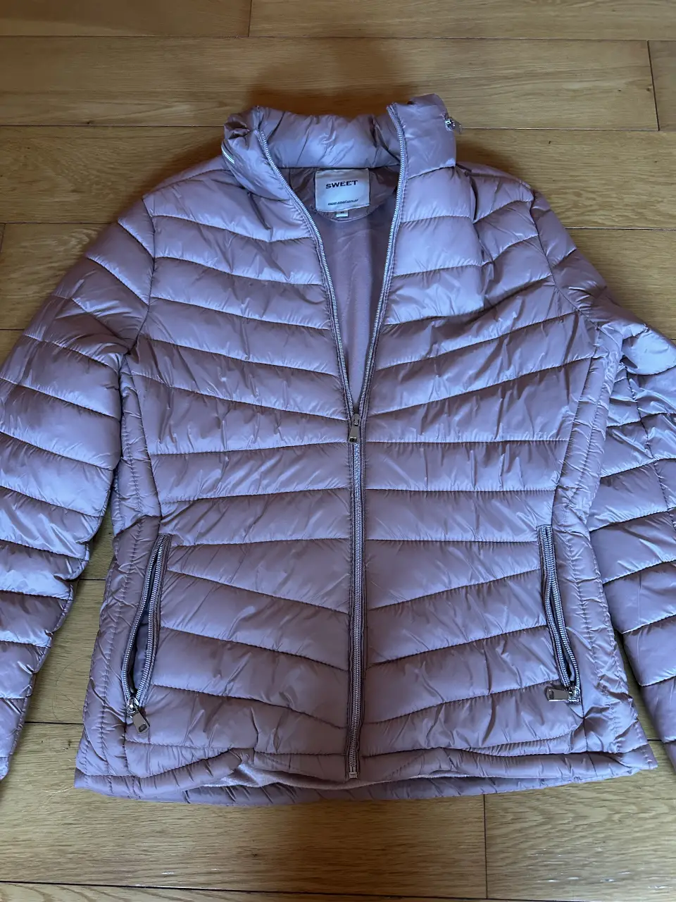 Campera Sweet acolchada color rosa, con cierre y bolsillos. Talle XL.