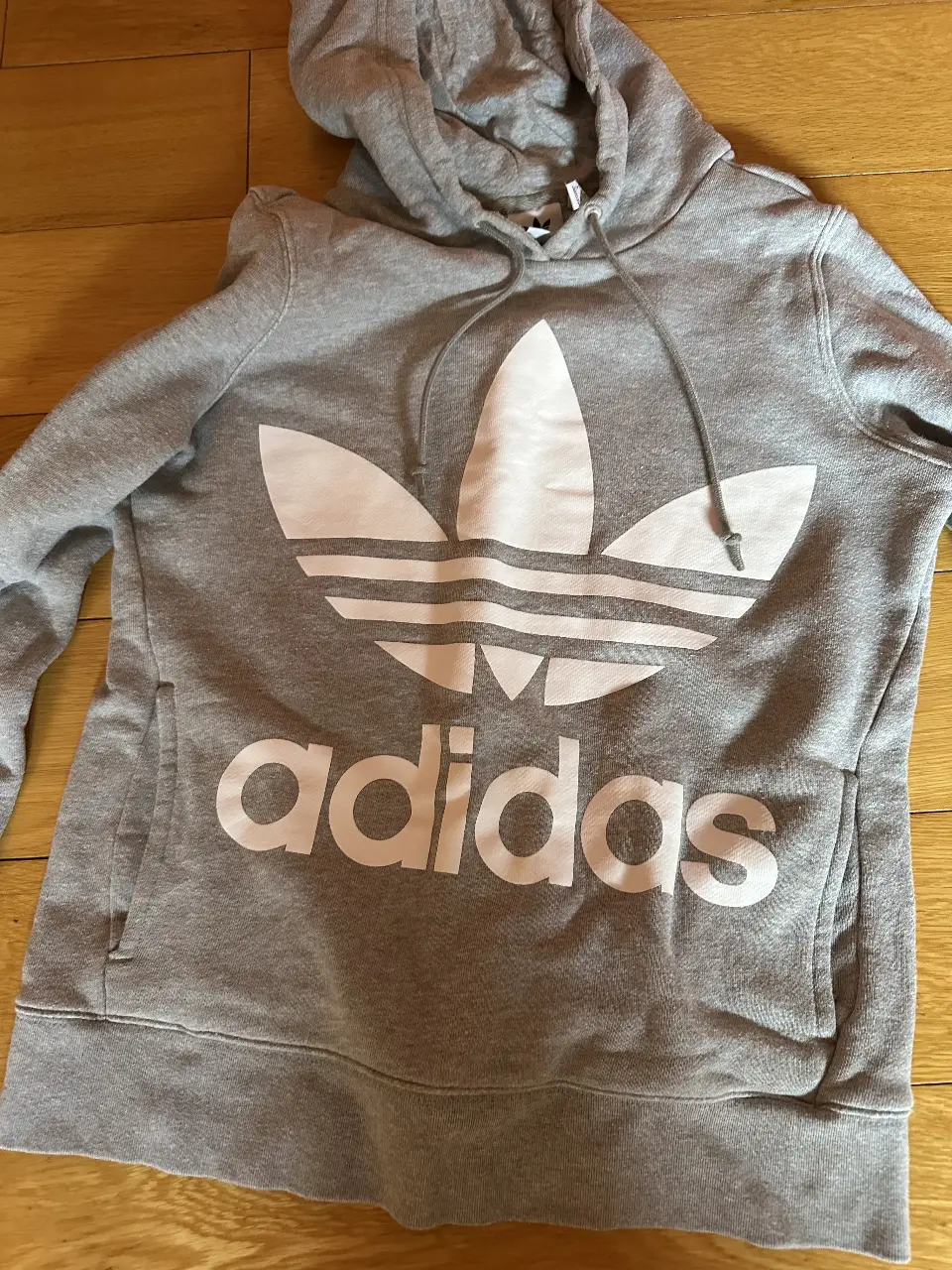 Buzo Adidas gris con capucha y el logo icónico en blanco. Talle XS, ideal para un look casual y deportivo.
