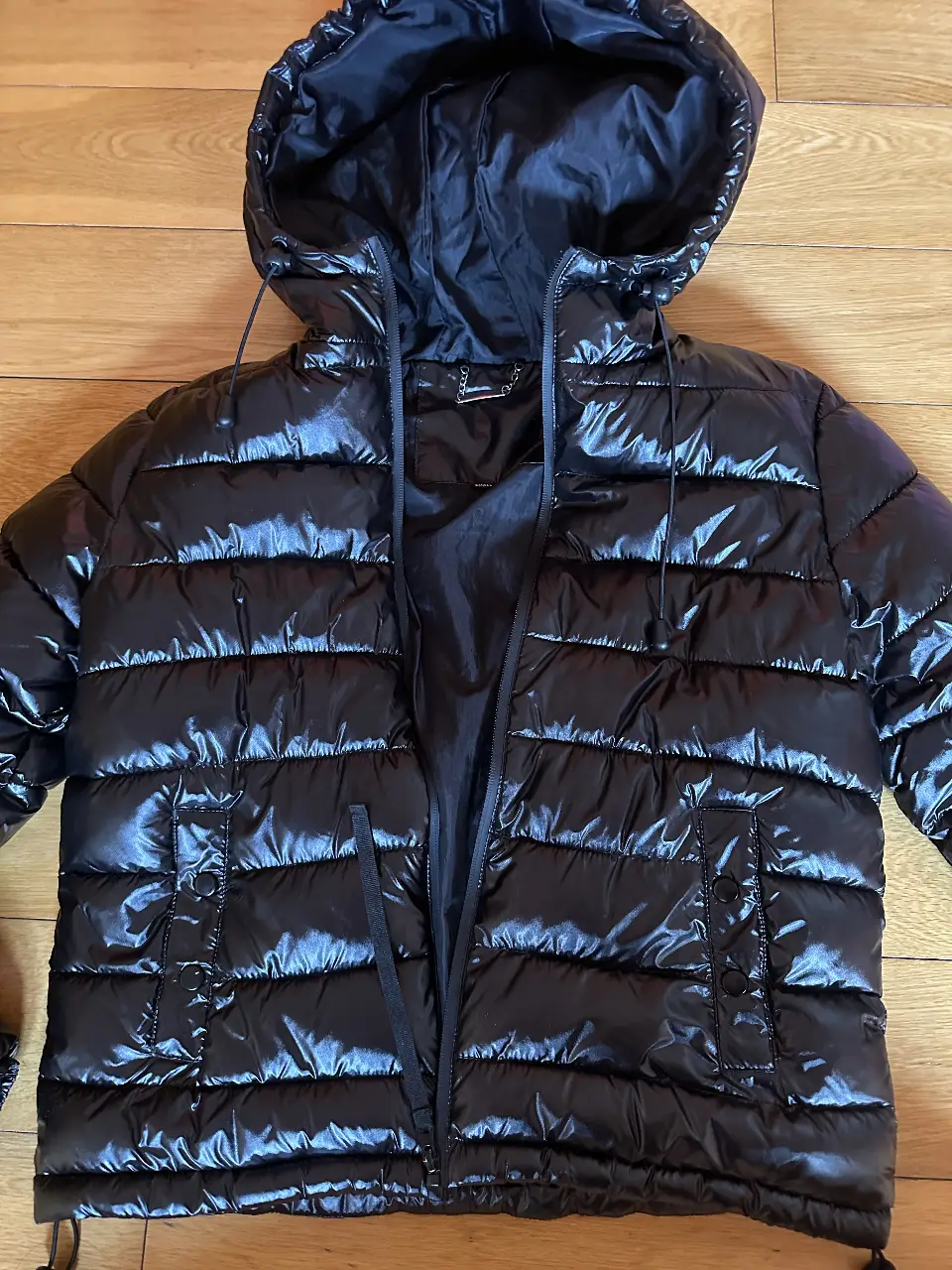 Campera inflable negra brillante con capucha marca Sweet. Ideal para el invierno, con un diseño moderno y abrigado. Talle small.