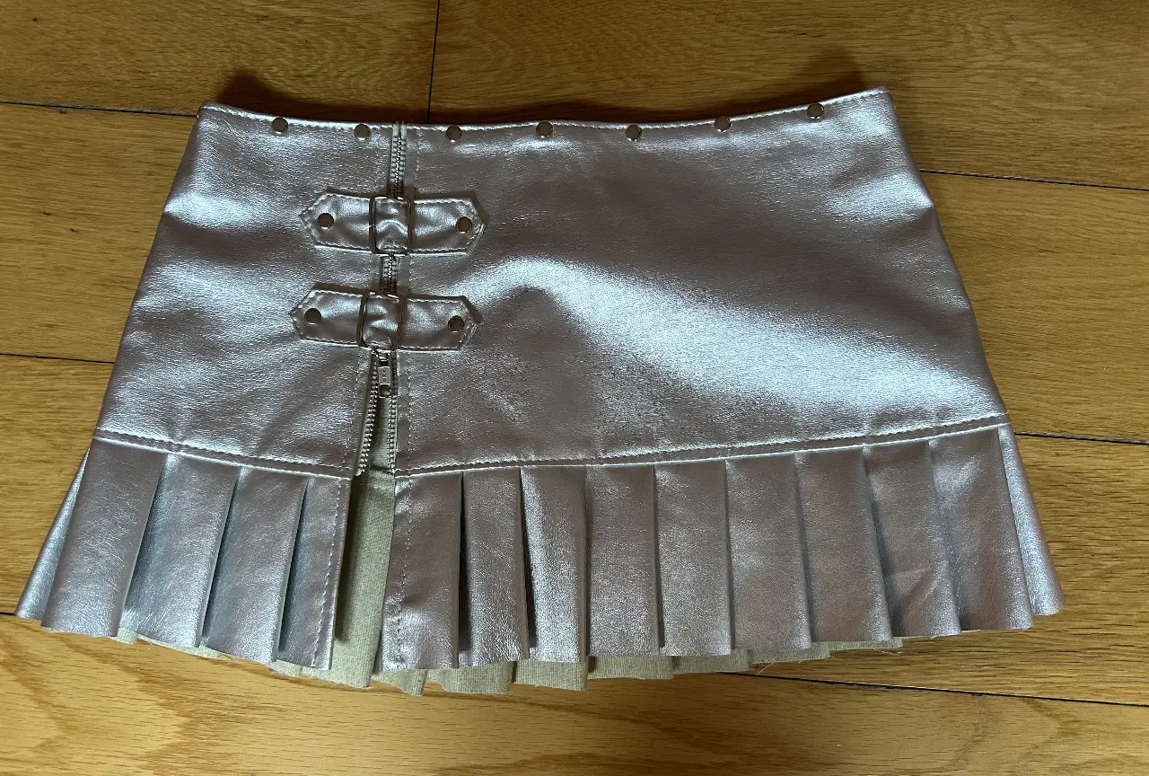 Minifalda plateada marca Hey Black con detalles de cierre y hebillas. Estilo Y2K, ideal para fiestas y salidas.