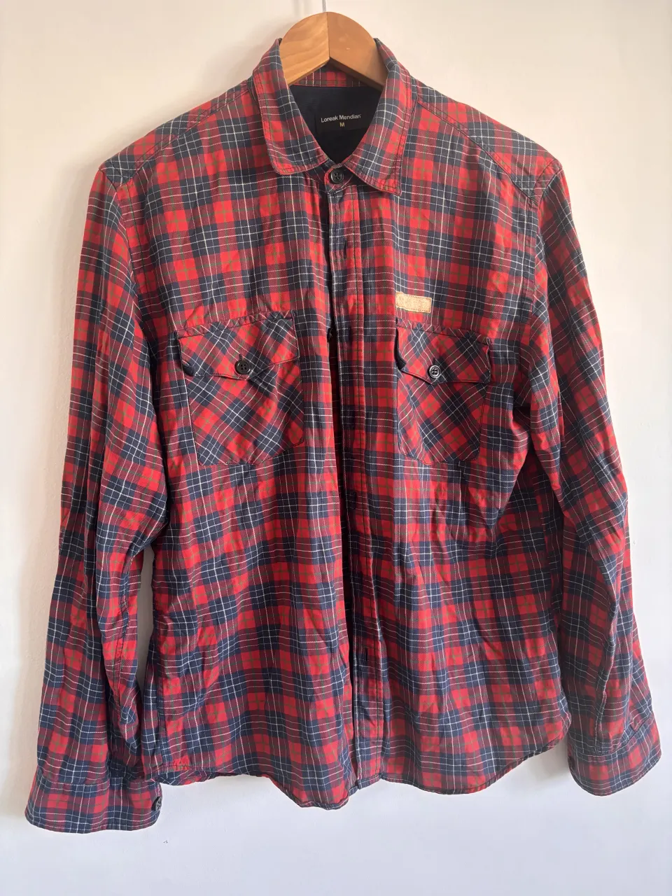 Camisa de leñador a cuadros rojos y azules, con dos bolsillos en el frente y detalles en cuero. Perfecta para un look casual y canchero. Prenda única en su especie. Marca española Loreak Mendian. Muy suave y de gran calidad. Perdió el logo en el pecho pero aún vale  la pena. prenda inmortal. 

