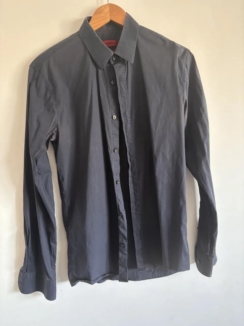 Camisa de vestir Hugo Boss color gris oscuro, corte slim fit. Perfecta para un look elegante y moderno, ideal para el trabajo o una salida. Cuello desgastsdo por el uso. 