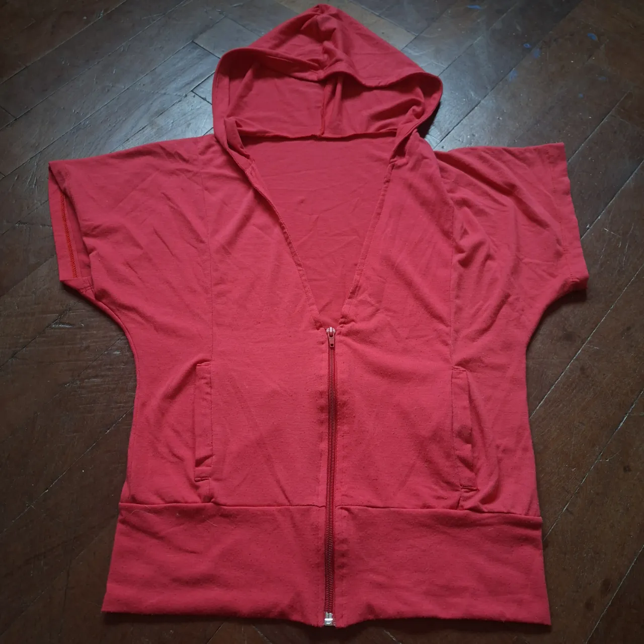 mini crop buzo rojo con capucha y cierre completo. Posee dos bolsillos frontales.