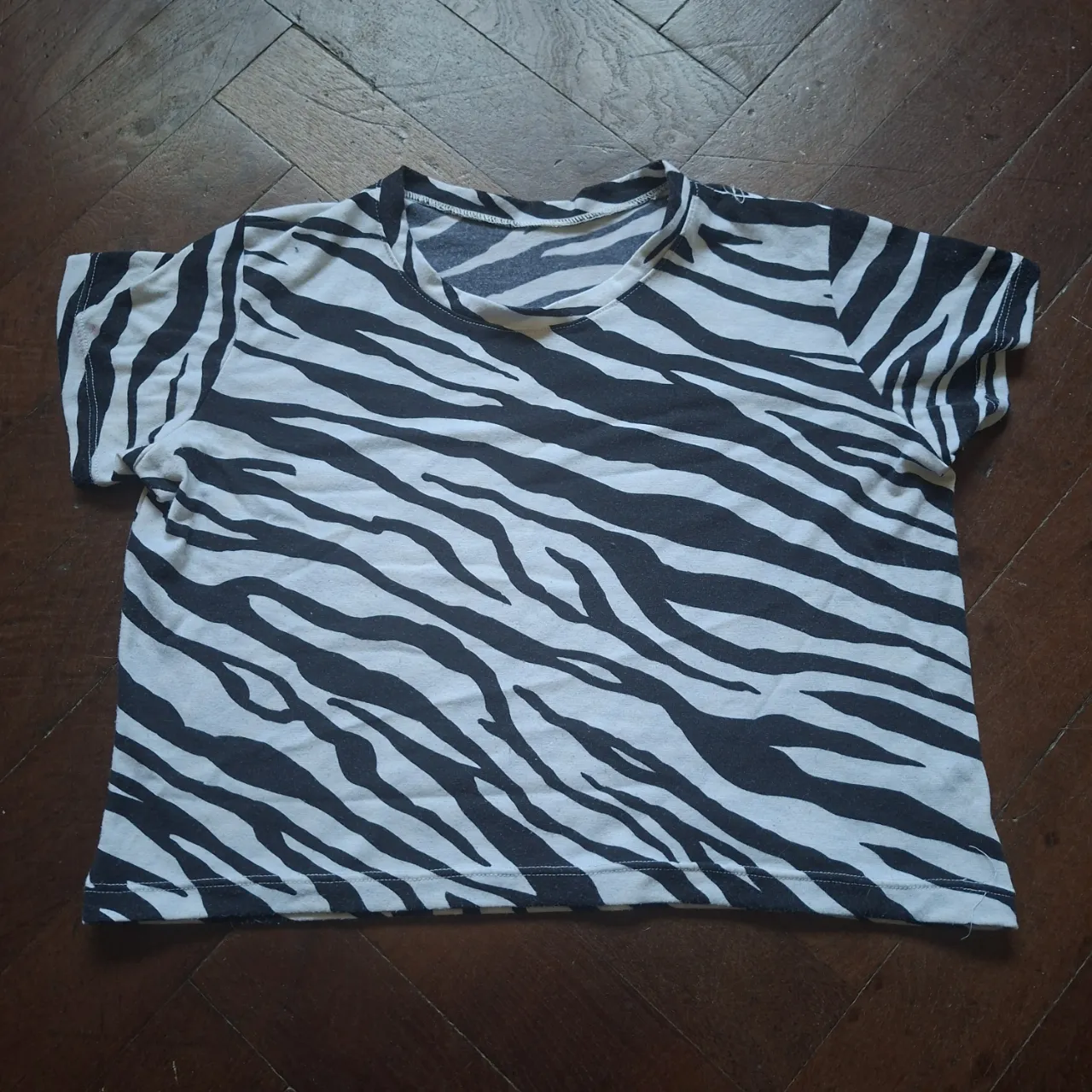 Remera corta estampada con motivo de cebra, manga corta y cuello redondo.