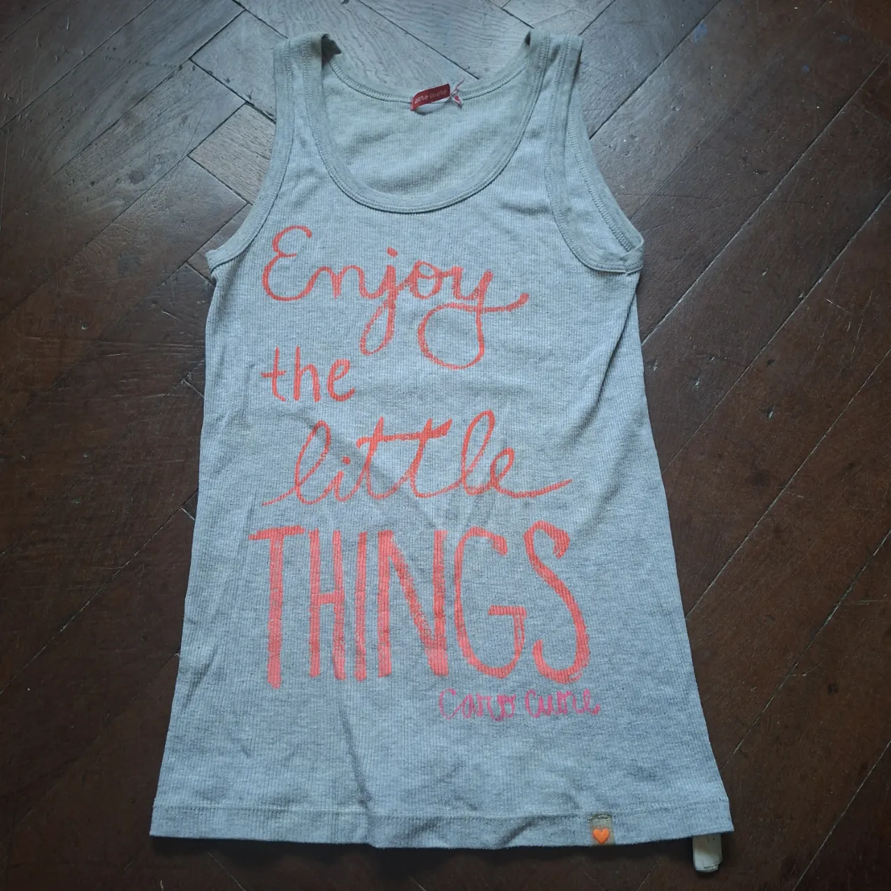 Musculosa gris de algodón acanalado con estampa "Enjoy the little THINGS" en color coral. Cuello redondo y sin mangas.