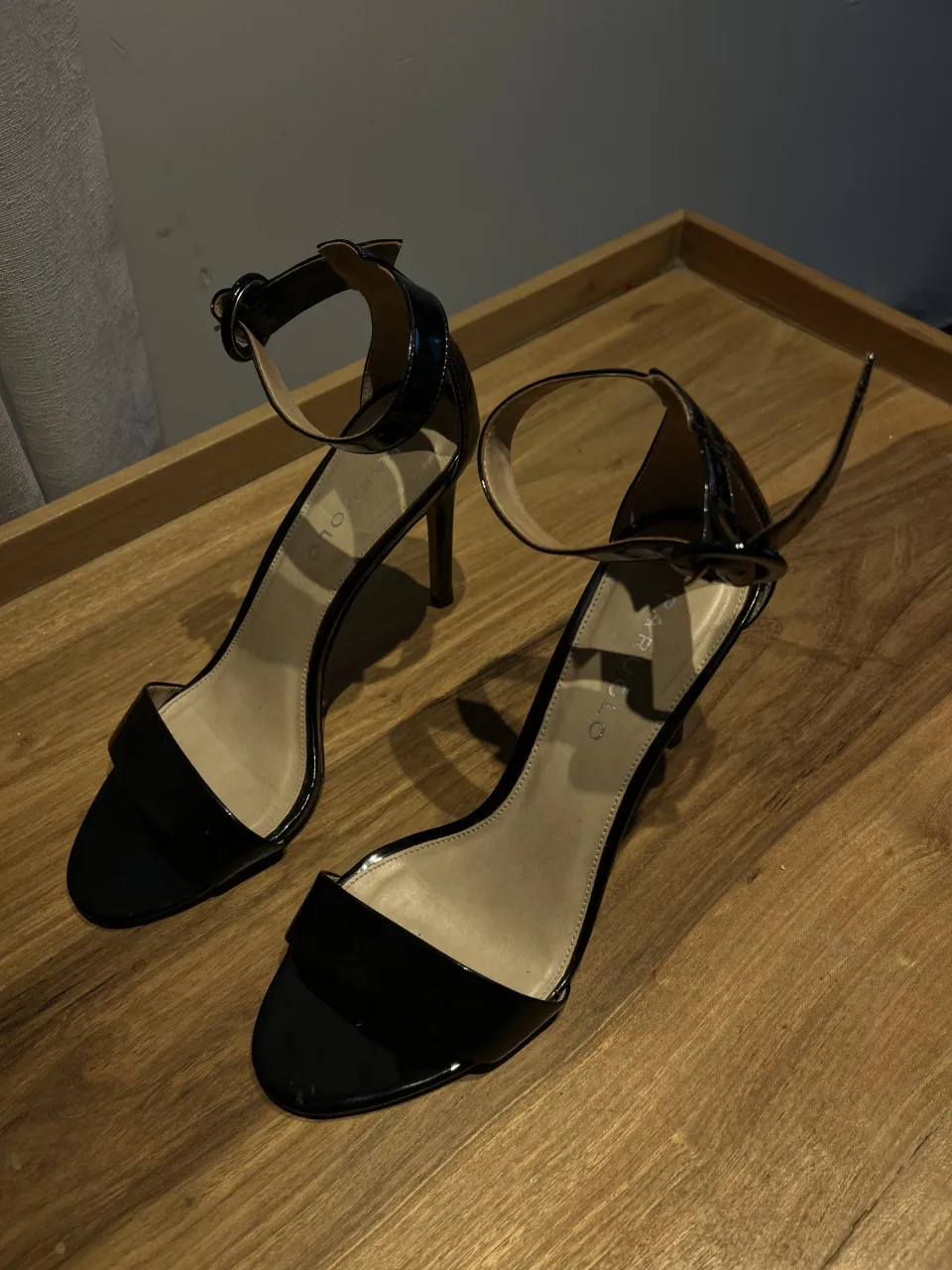 Sandalias negras de charol con tira en el tobillo y hebilla. Taco fino. Un solo uso. Impecables