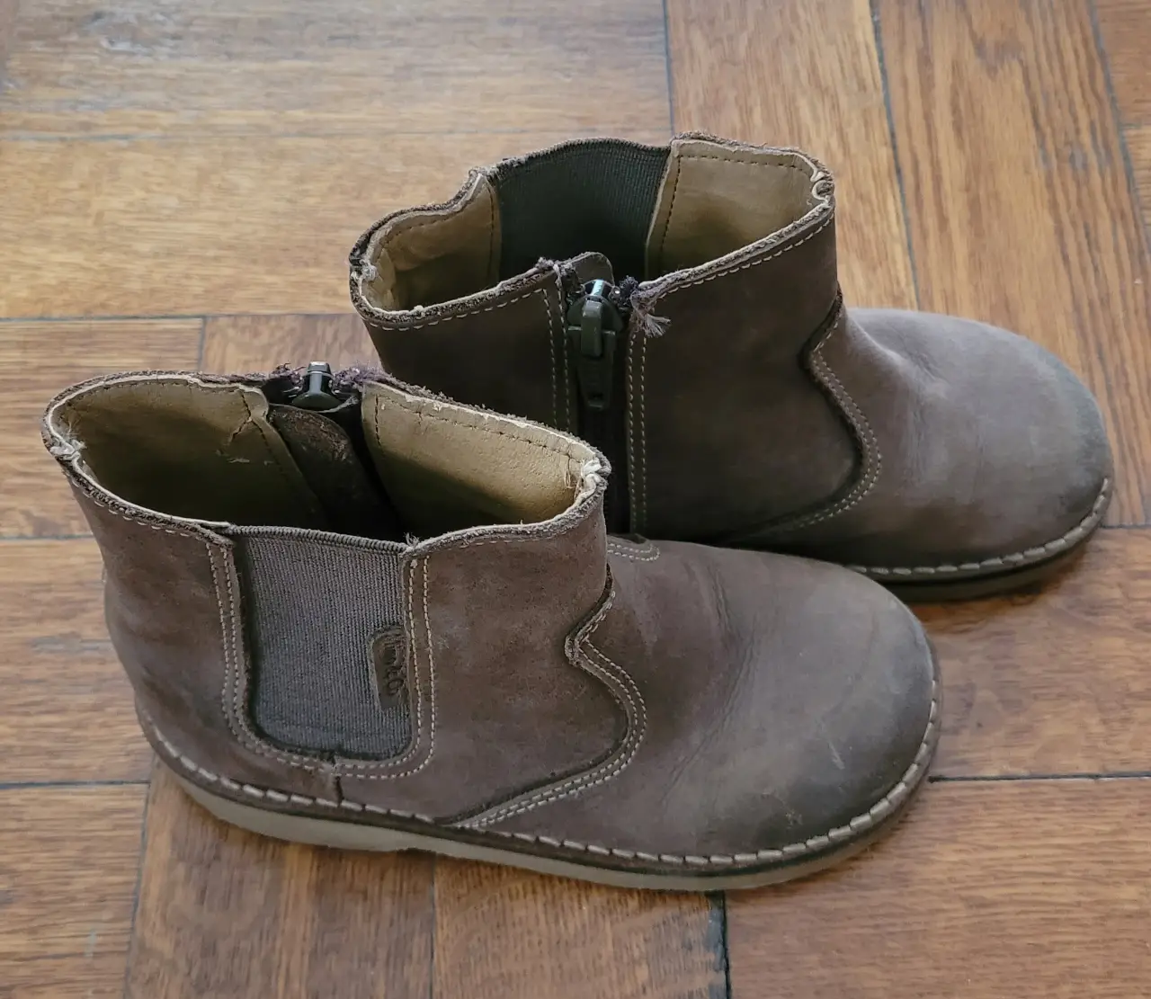 Botines de gamuza marrón para niña, con cierre lateral y detalle elástico. Ideales para un look casual y cómodo.