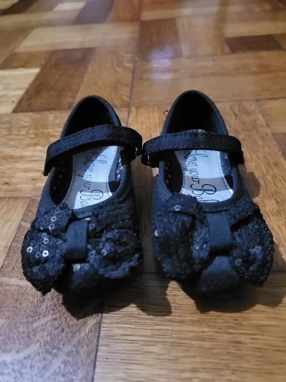 Hermosas ballerinas negras para niña, con moño de lentejuelas y cierre de hebilla. Perfectas para ocasiones especiales.