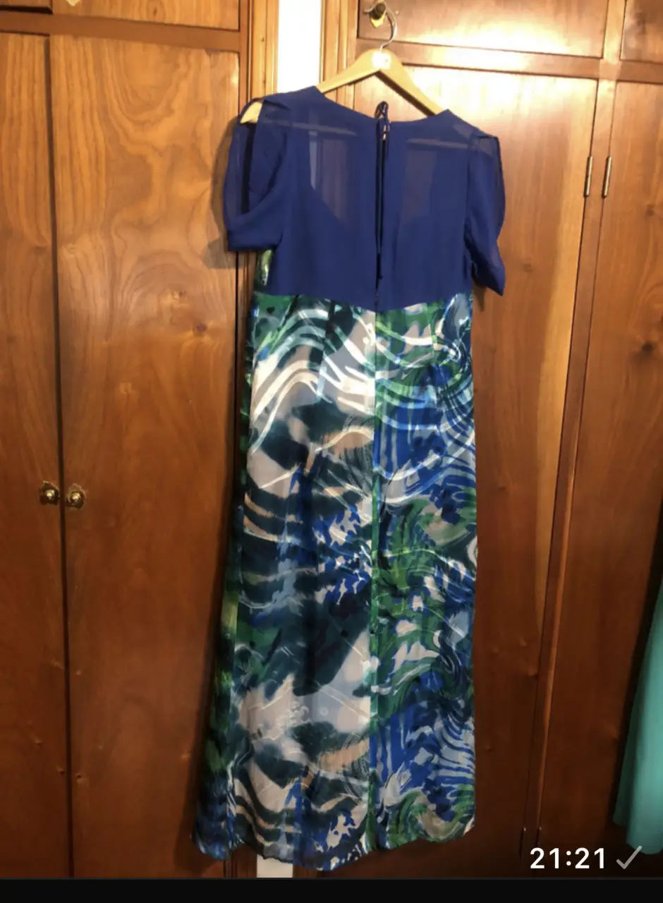 Vestido largo de mujer, con escote en la espalda y mangas cortas. La parte superior es azul, mientras que la falda presenta un estampado en tonos verdes y azules. En Crepe Georgette. Ideal para eventos especiales o fiestas. Madrinas