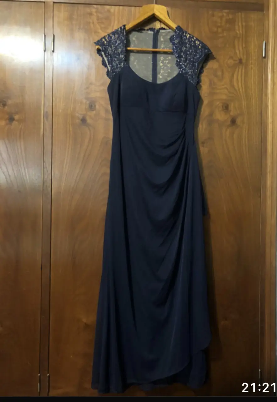 Elegante vestido largo de fiesta en color azul marino, con detalles de encaje en los hombros y escote. Ideal para eventos formales y ocasiones especiales.