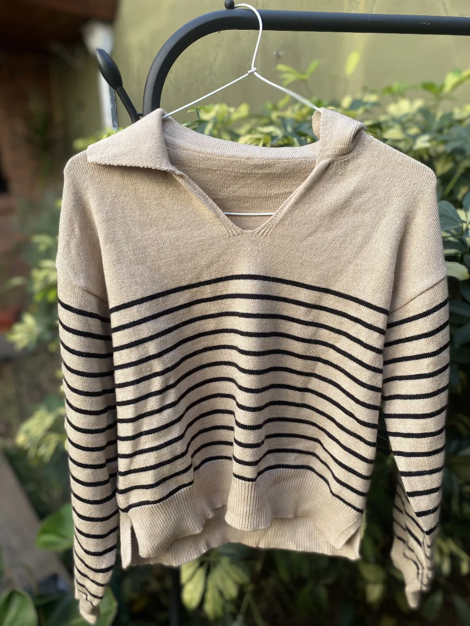 Sweater de mujer a rayas horizontales en color crudo y negro. Cuello en V y mangas largas. Ideal para un look casual y cómodo.