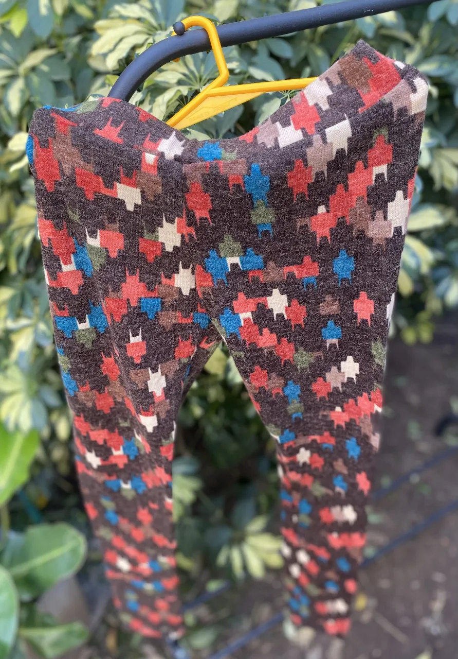 Calzas de mujer con estampado geométrico en tonos marrones, rojos, azules y blancos. Ideal para un look casual y cómodo.