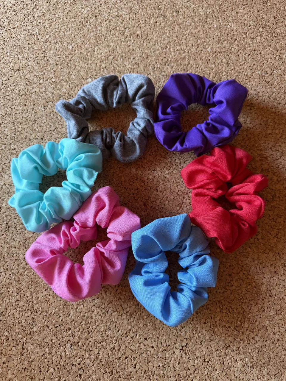 Set de 6 scrunchies de tela en colores surtidos: gris, violeta, rosa, celeste, azul, rojo y rosa claro.