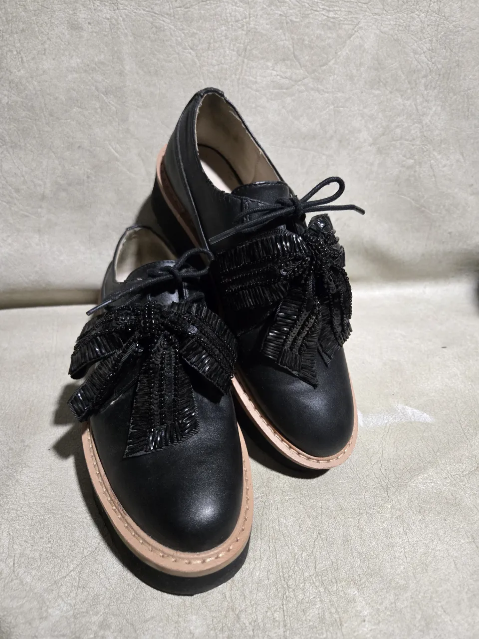 Zapatos negros estilo Oxford con detalle de flecos y tachas en la capellada. Suela plataforma gruesa y cordones. Ideales para un look canchero y moderno.
