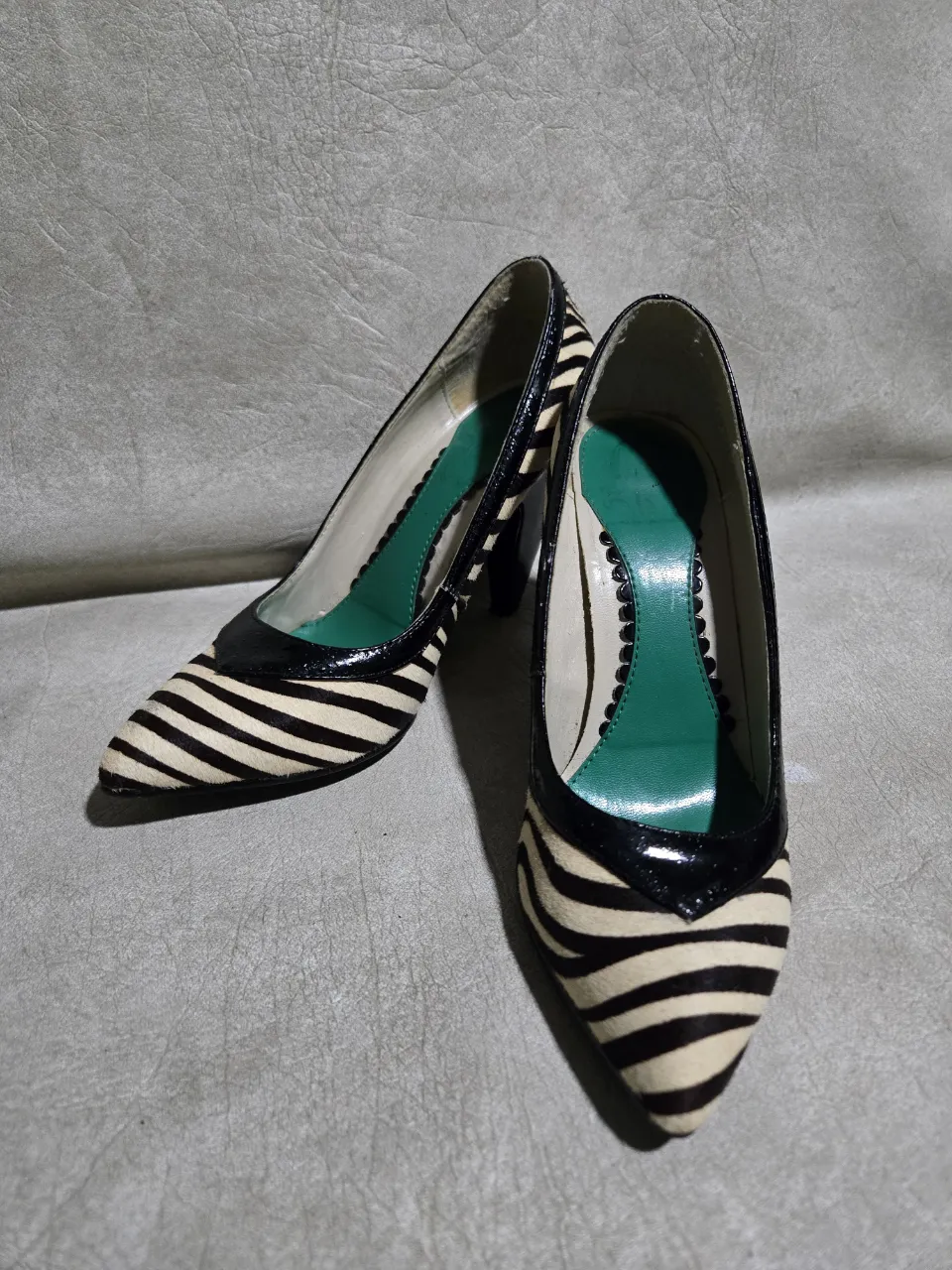 Zapatos de taco alto con estampa de cebra. Un clásico que nunca pasa de moda, ideales para darle un toque salvaje y sofisticado a cualquier look. Perfectos para una salida nocturna o un evento especial. Pequeño detalle en el taco, se puede ver en la foto.