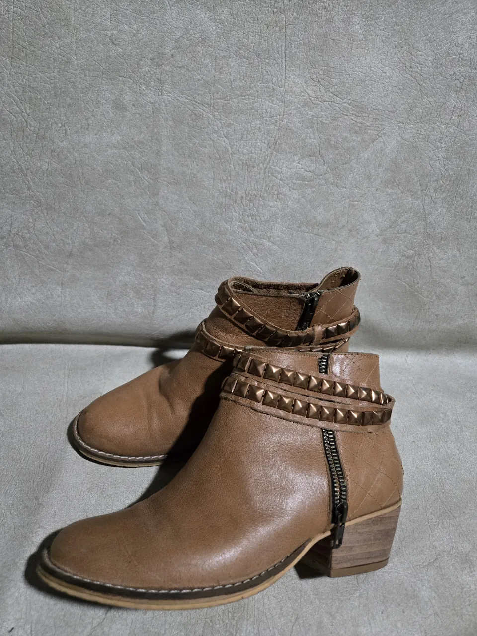 Botitas de cuero color suela, con tachas doradas y cierre lateral. Ideales para darle un toque rocker a tu look.