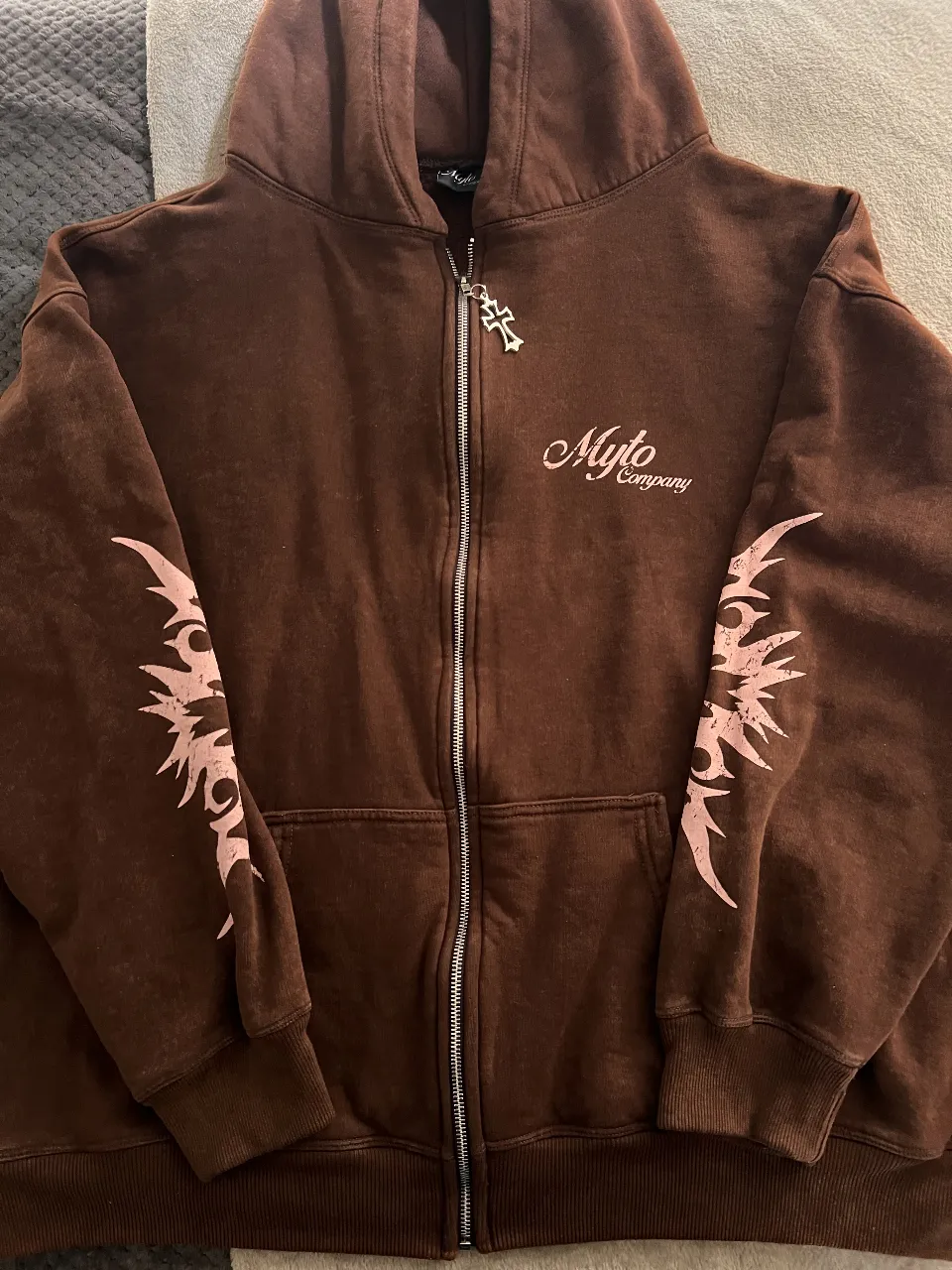 Buzo con cierre marrón con detalles en rosa en las mangas y en la capucha. 
Algodón frizado.
Oversized, equivale a XL/XXL