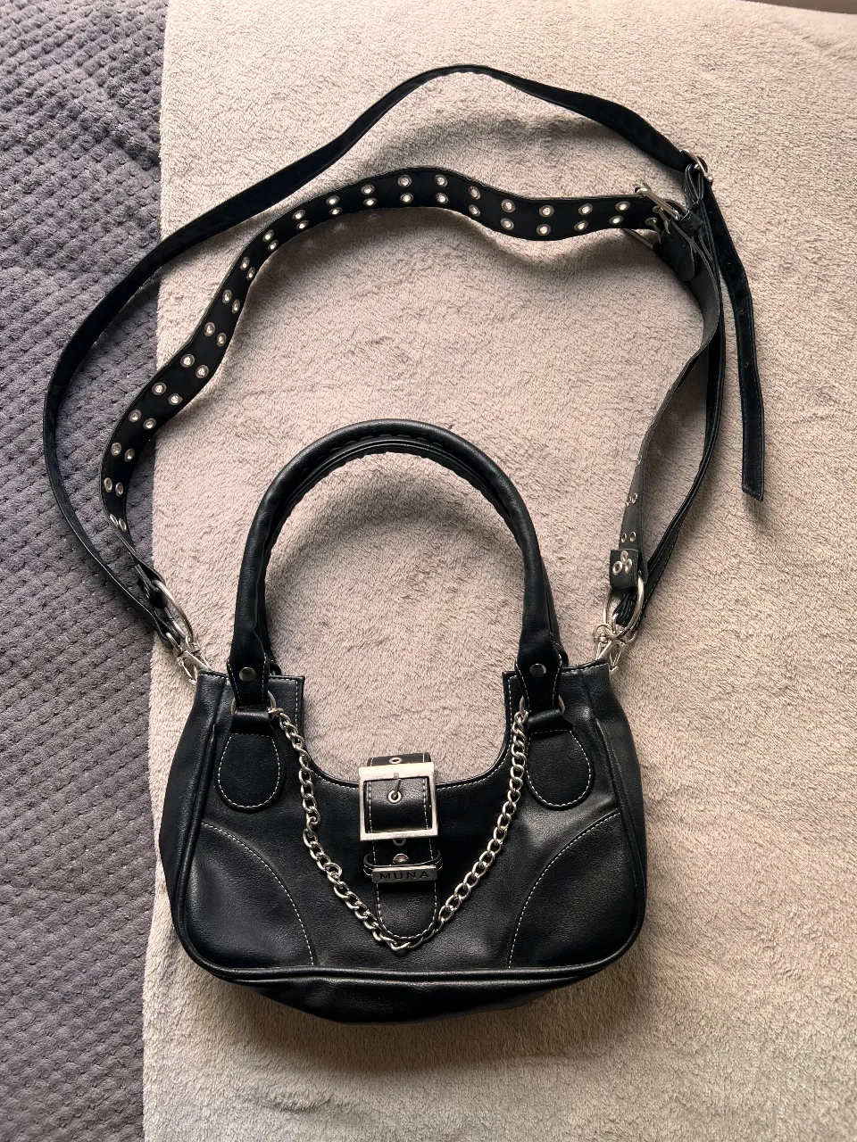 Cartera negra con correa ajustable y detalles de cadena. Ideal para un look Y2K o rocker. Cuenta con un compartimento principal y un bolsillo interno con cierre.
La usé una sola vez