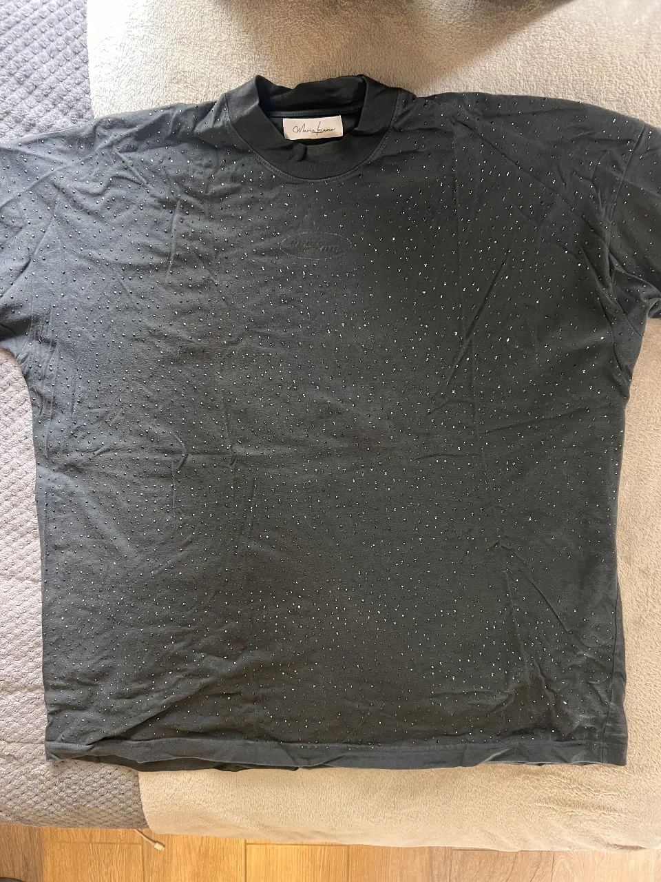 Remera negra con detalles de strass. Cuello redondo y manga corta. Ideal para un look casual y canchero.
