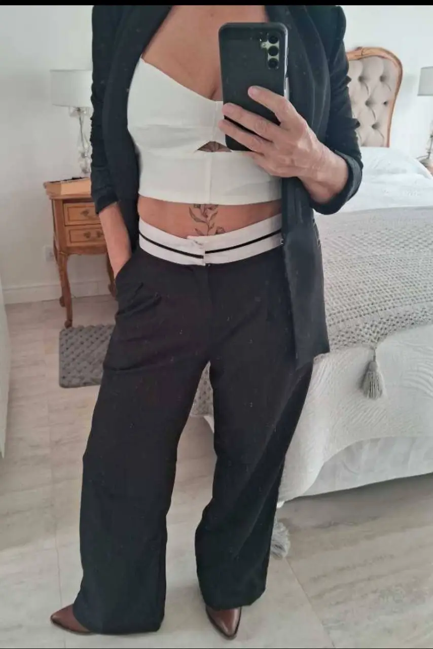 Pantalón sastrero negro con detalle de cintura blanca. Corte amplio y elegante, ideal para un look sofisticado. Sofia Sarkany. Largo 101 cm, cintura 72cm, tiro 34 cm.