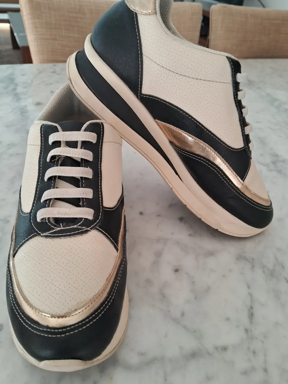 Zapatillas deportivas para mujer, con detalles en dorado y negro. Diseño moderno y cómodo, ideales para uso diario.