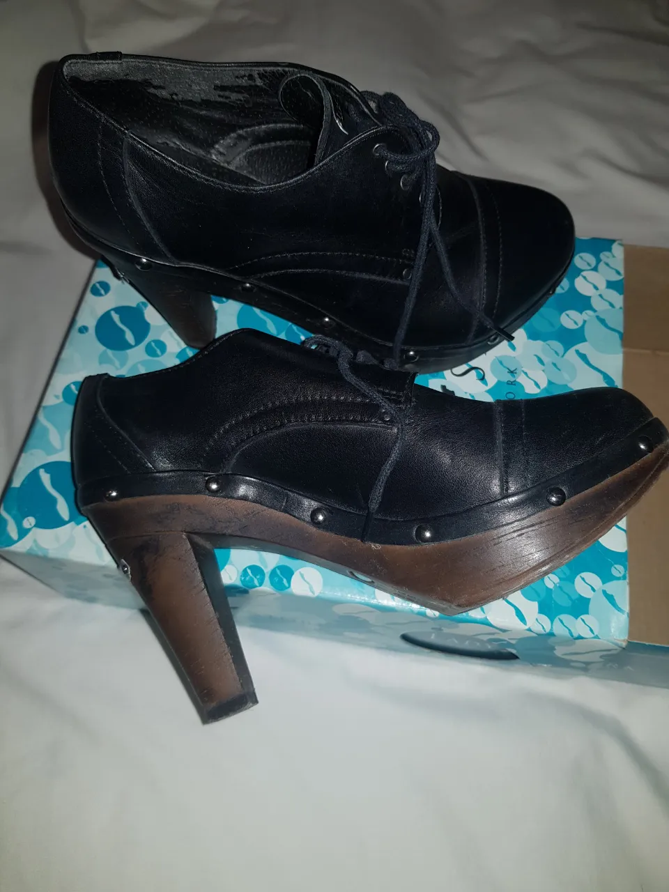 Botines de cuero negro con taco de madera y detalles de tachas. Estilo vintage.
