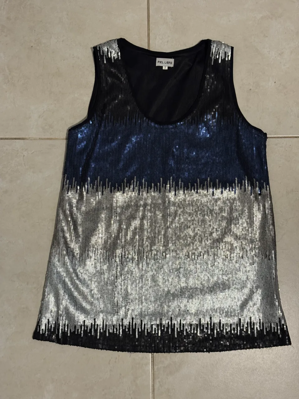 Top plateado y azul con lentejuelas, ideal para fiestas o salidas nocturnas. Diseño moderno y llamativo.