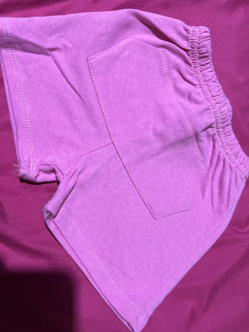 Shorts de algodón color rosa con cintura elastizada y bolsillos traseros.