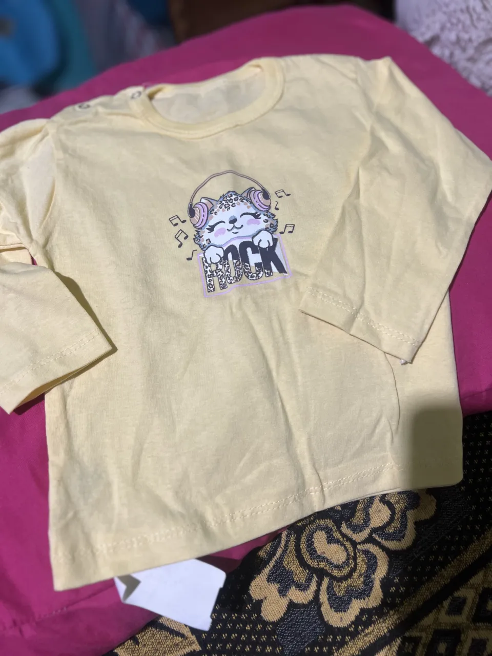 Remera amarilla de manga larga con estampa de gatito con auriculares y la palabra "ROCK".