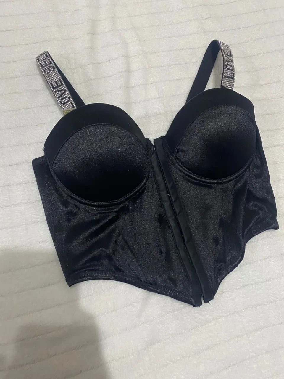 Corpiño negro con detalles brillantes en los breteles. Diseño tipo corset con cierre al frente y ballenas para un ajuste perfecto. Ideal para un look audaz y glamoroso.