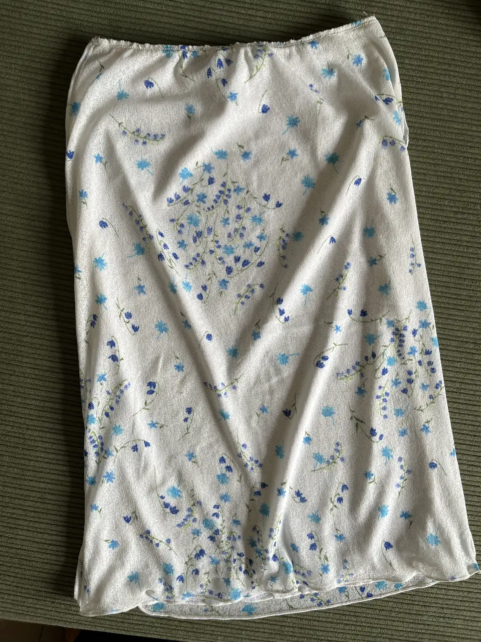 Falda media de tela un poco traslúcida (tiene forro) con estampado floral en tonos azules sobre fondo blanco. Estilo dosmiloso 