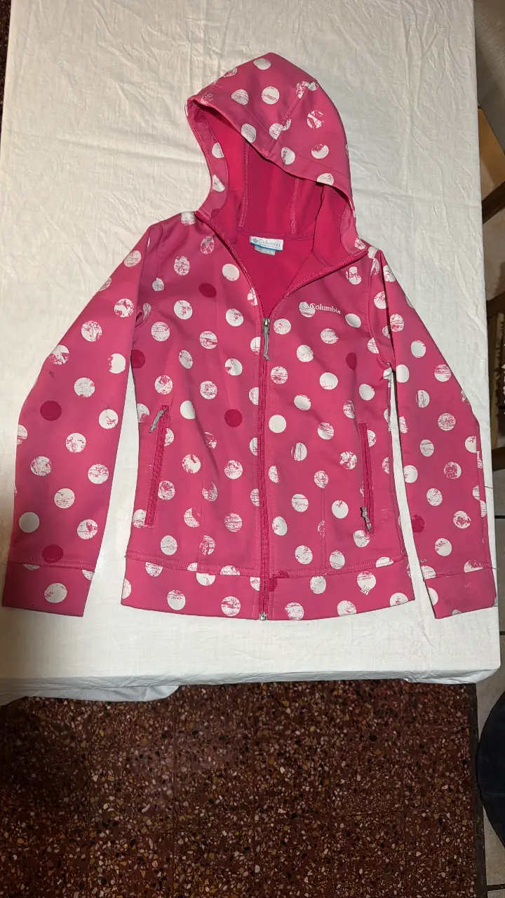 Buzo con cierre Columbia para niña, color rosa con estampado de lunares blancos. Con capucha y bolsillos. Ideal para el día a día.