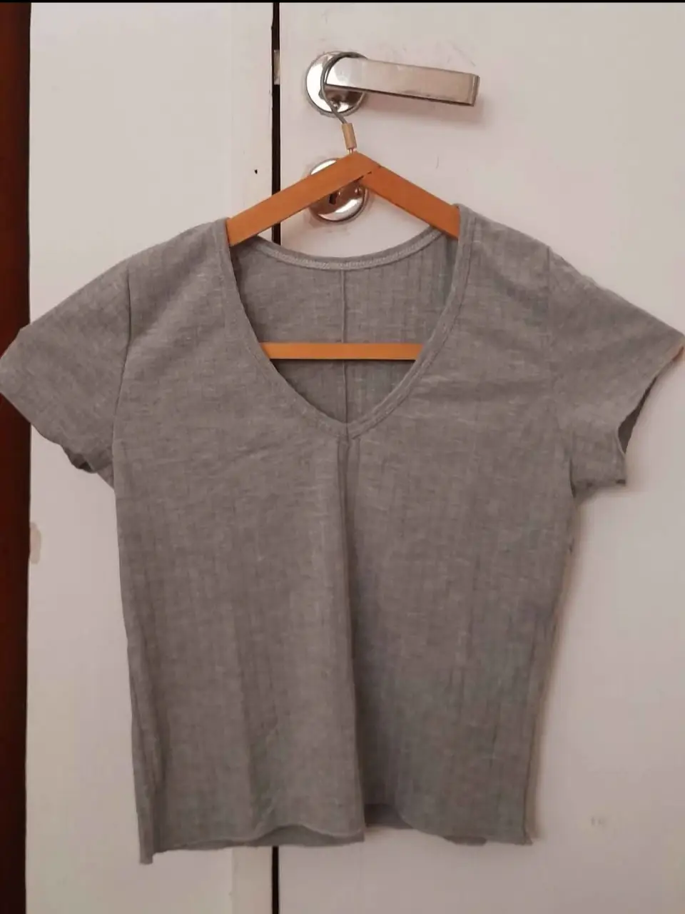 Remera gris de mujer, con cuello en V y manga corta. Ideal para un look casual y cómodo.