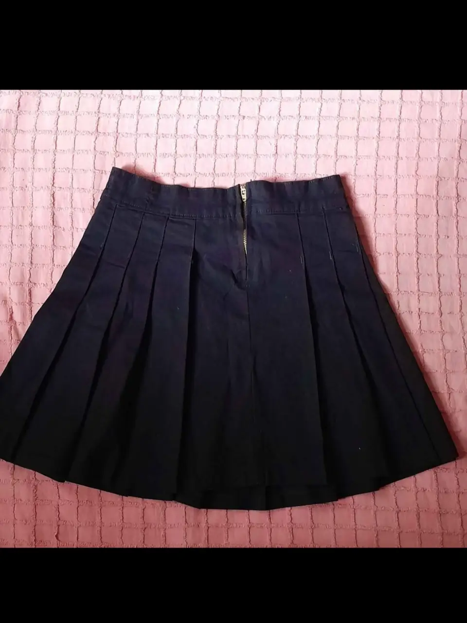 Minifalda plisada negra, ideal para un look colegial o casual. Confeccionada en algodón, perfecta para combinar con diferentes estilos.