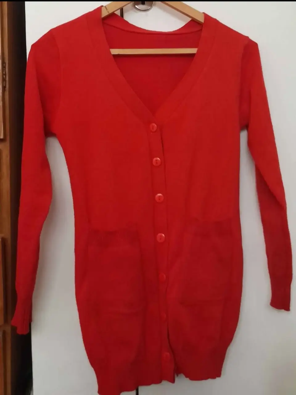 Cardigan rojo de punto con cuello en V y botones. Ideal para un look casual y abrigado.