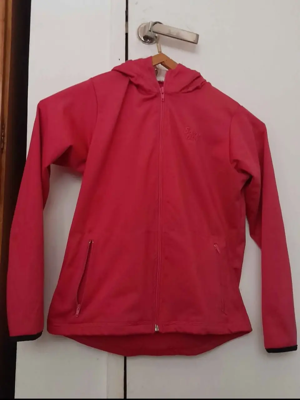 Campera deportiva de niña, color rosa, con capucha y bolsillos. Talle 10.