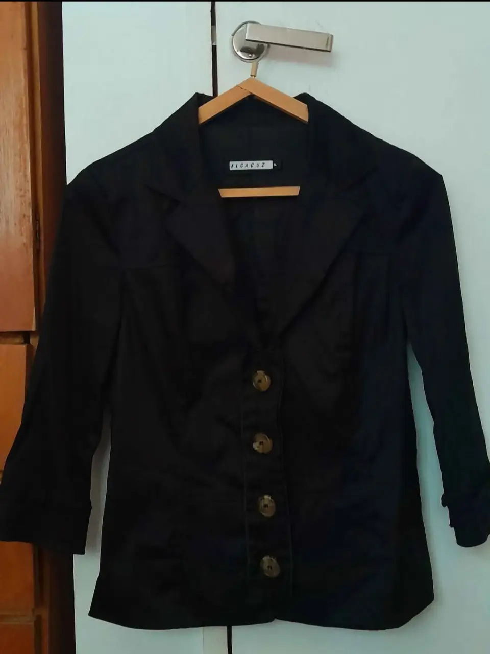 Blazer negro de mujer, con botones y mangas 3/4. Ideal para un look elegante y versátil.