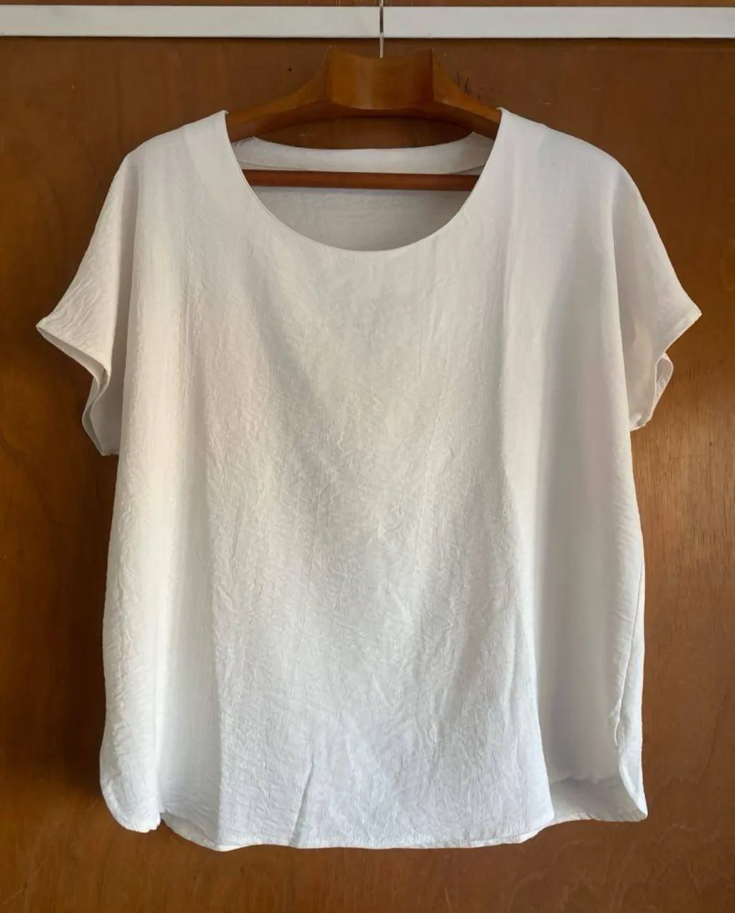 Blusa blanca de tela liviana, con mangas cortas y cuello redondo. Ideal para un look fresco y casual. la tela es como crepe de seda 