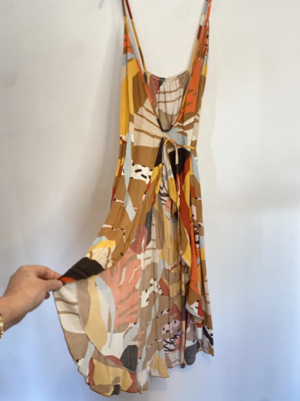 Vestido largo de mujer con estampado abstracto en tonos marrones, amarillos y naranjas. Diseño con tirantes finos y detalle de lazo en la cintura. Ideal para un look bohemio y fresco. Talle único ya que se ajusta a voluntad. Único detalle esa manchita que se ve en la última foto