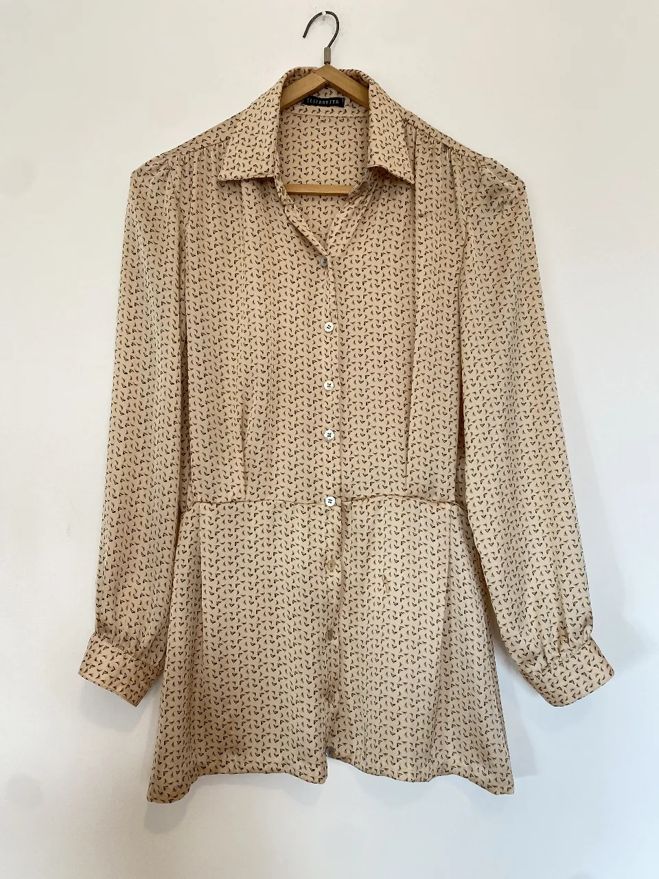 Blusa de mujer con estampado de diseño repetitivo en tonos crudo y marrón. Corte clásico con cuello camisero, botones frontales y detalle de ajuste en la cintura. Mangas largas con puños. Tiene los detalles que se ven en las fotos x eso el precio 
Axilas 48, hombros 40, mangas 57, largo 64