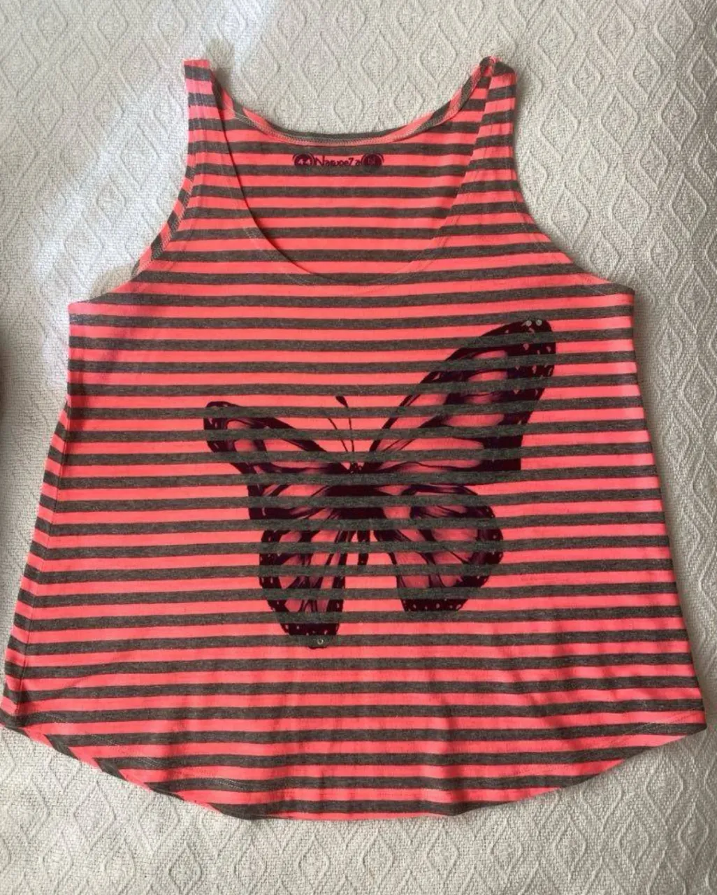 Musculosa de mujer a rayas horizontales en color rosa y gris. Diseño con un estampado de mariposa en el frente. Ideal para un look casual y fresco.