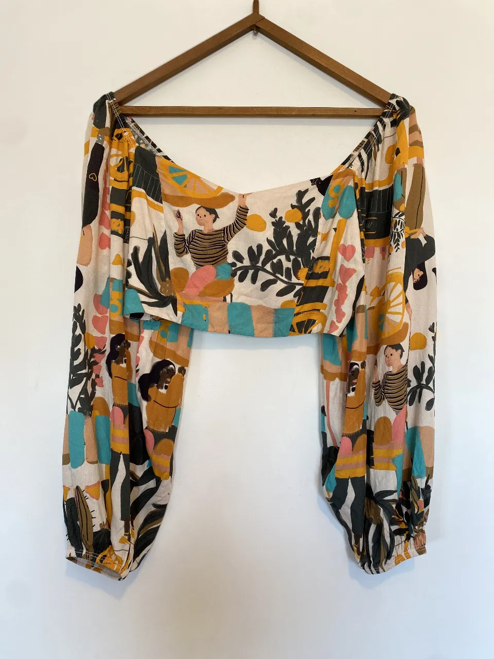 Blusa estampada con mangas largas y diseño artístico. Ideal para un look bohemio y casual. Único detalle ese descosido al costado
