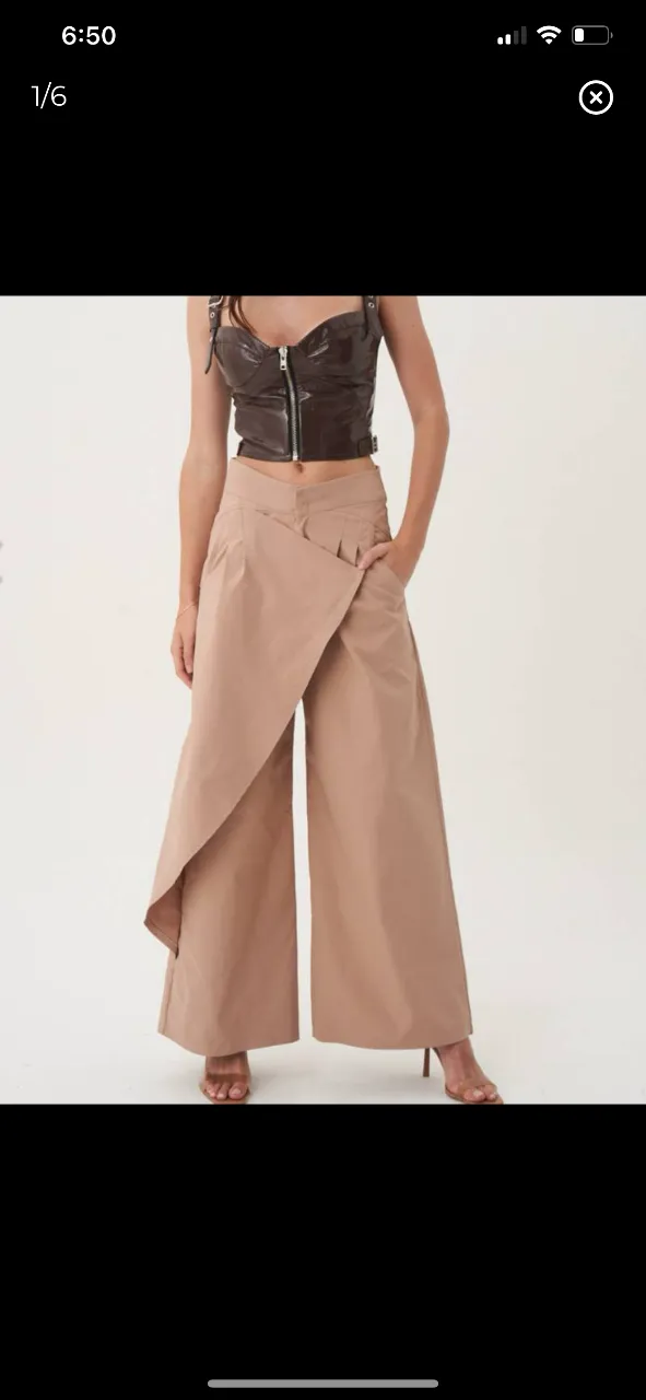 Pantalón sastrero de mujer con diseño envolvente. Corte palazzo, tiro alto y detalle de solapa asimétrica. Disponible en color negro. Ideal para un look elegante y moderno. modelo North talle 38