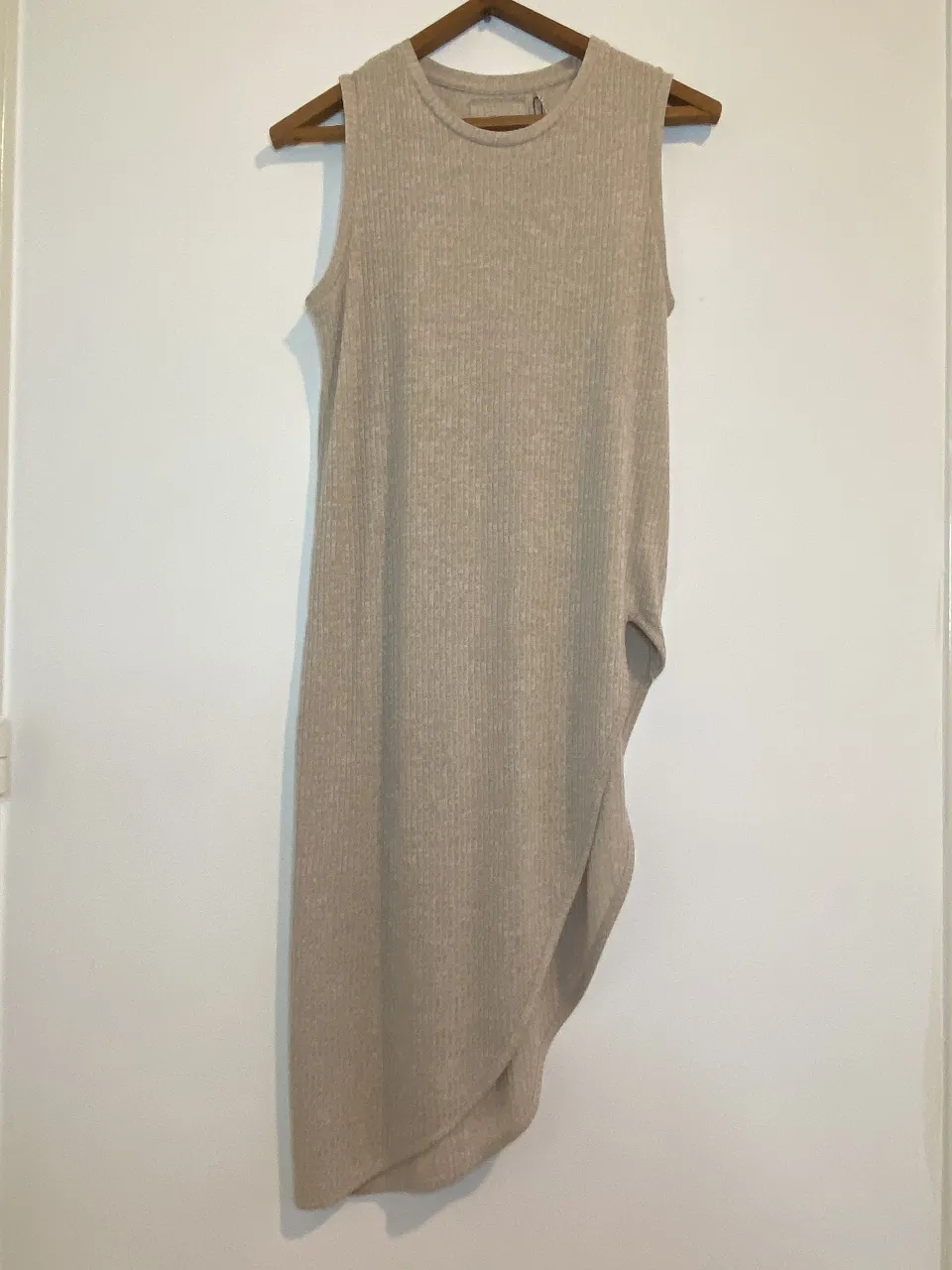 Vestido midi de mujer, sin mangas, con diseño asimétrico y detalle drapeado. Confeccionado en tejido de punto acanalado, ideal para un look casual y moderno. axilas mínimo 40 máximo 50 el largo más largo 109, y el largo hasta el Tajo 52